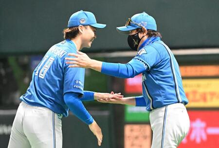 　ソフトバンクに勝利し、山崎（左）をねぎらう新庄監督