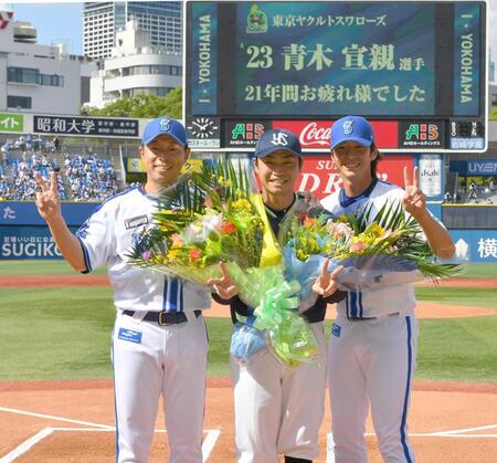 　田中コーチ（左）と度会（右）から花束をもらい写真に納まる青木（撮影・持木克友）