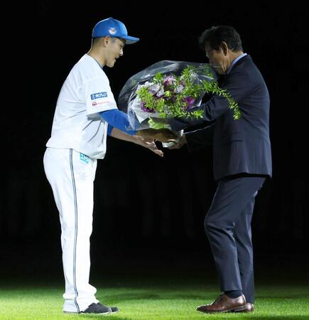 　引退セレモニーで鍵谷（左）に花束を贈る栗山ＣＢＯ（撮影・中島達哉）