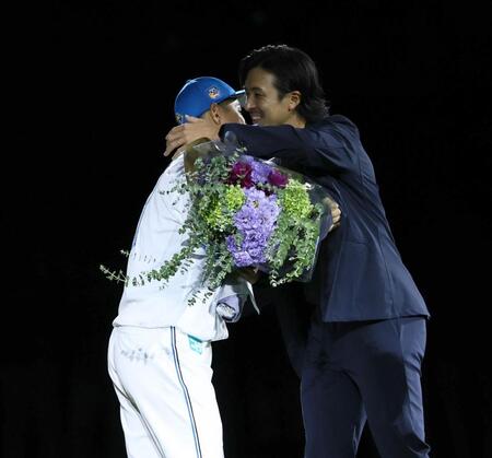 　引退セレモニーで鍵谷（左）に花束を贈り、抱き合う上沢（撮影・中島達哉）