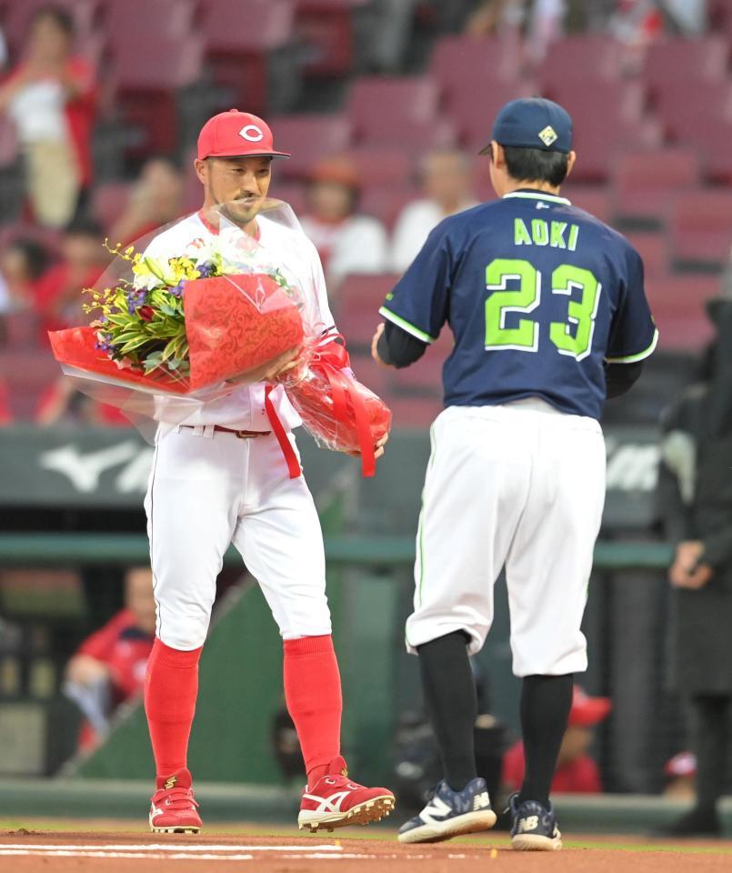 　菊池は今季限りで現役を引退する青木に花束を渡す（撮影・市尻達拡）