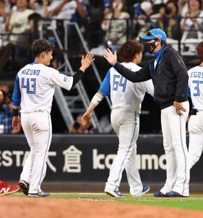 　９回、サヨナラ勝ちでＣＳ本拠地開催を決め、水野（左から２人目）ら日本ハムナインを迎える新庄監督（中央）＝撮影・中島達哉