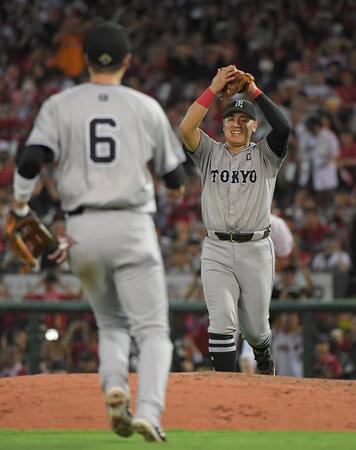 　優勝の瞬間、バンザイをしながらマウンドに駆け寄る岡本和（右）＝撮影・佐藤厚