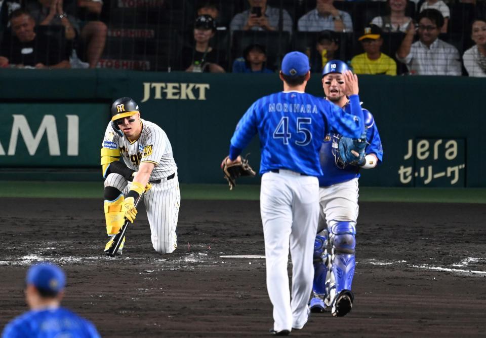 　９回、空振り三振に倒れ、悔しがる佐藤輝（撮影・飯室逸平）