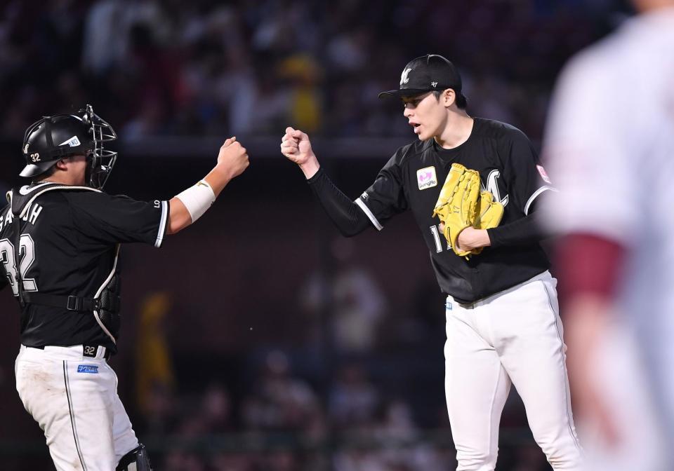 　９回１失点完投で今季１０勝目を挙げ、佐藤（左）とグータッチを交わす佐々木（撮影・開出牧）