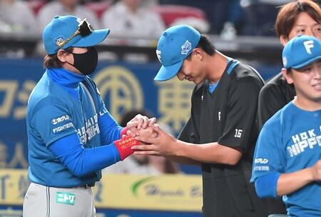 　プロ初勝利を挙げ新庄監督（左）とがっちり握手を交わす達（撮影・開出牧）