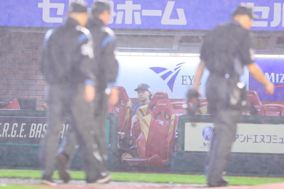 　７回、雨が強まり中断となり、ナインがベンチ裏へ引っ込む中、１人ベンチでグラウンドを見つめる宮城