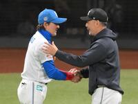 　試合後、新庄監督（左）と握手を交わし、勝利をたたえる吉井監督（撮影・伊藤笙子）