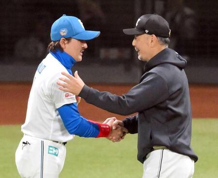 　試合後、新庄監督（左）と握手を交わし、勝利をたたえる吉井監督（撮影・伊藤笙子）