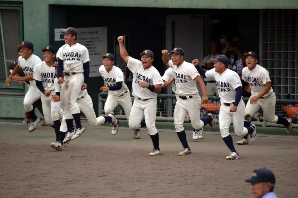 　優勝が決まり、ベンチから飛び出す大商大・渡部（右から４番目）