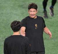 　試合前、大勢（手前）と会話を交わす菅野（撮影・伊藤笙子）