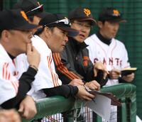 　原監督（奥）の横で試合を見る橋上コーチ＝２０１２年