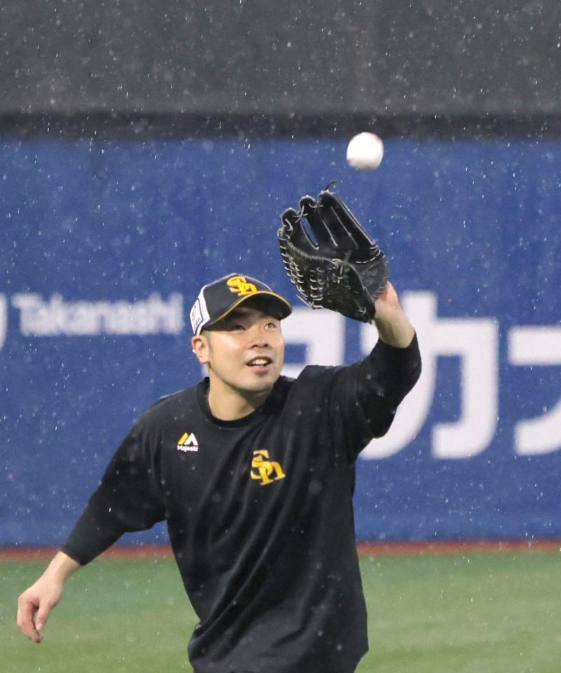 　激しい雨の中、柳田が投げたボ-ルを捕球する近藤（撮影・西岡正）