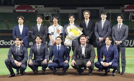 　現役引退の記者会見を終え、マウンドで写真に納まるプロ野球ソフトバンクの和田毅投手（後列中央）ら＝みずほペイペイドーム