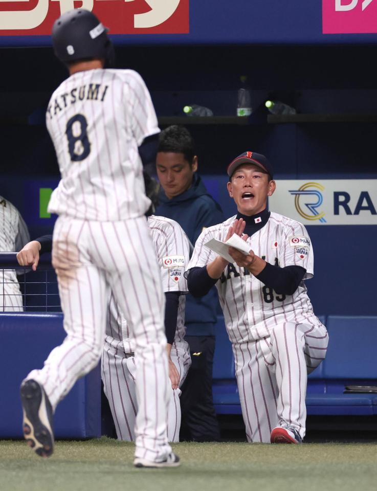 　６回、生還した辰巳を迎える井端監督