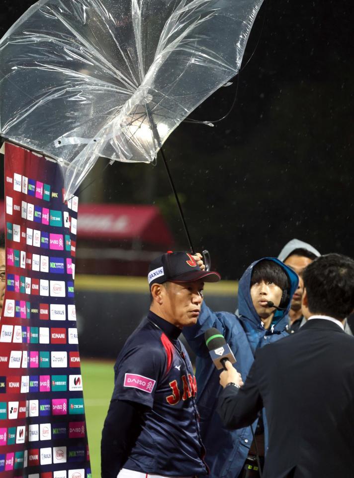 　雨と強風の中、インタビューを受ける井端監督（撮影・山口登）