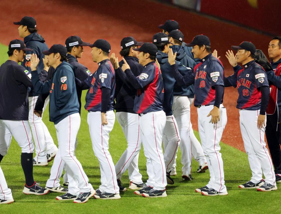 　ドミニカに勝利し、選手とタッチを交わす井端監督（右端）