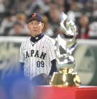 　表彰式でトロフィーを見つめる井端監督（撮影・伊藤笙子）