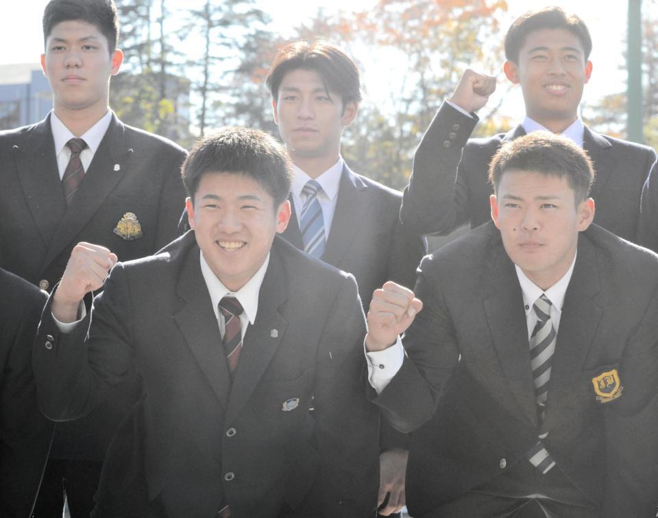 　施設訪問し、ガッツポーズを見せるドラフト１位・石塚裕惺（写真左）と、同３位・荒巻悠