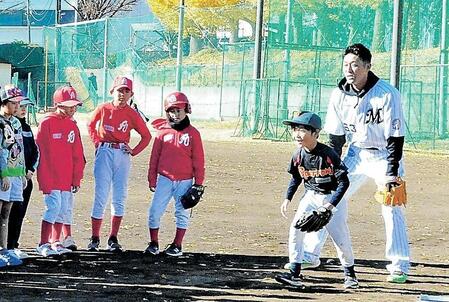 　守備練習を教える千葉日大一ナインと青松氏（右端）