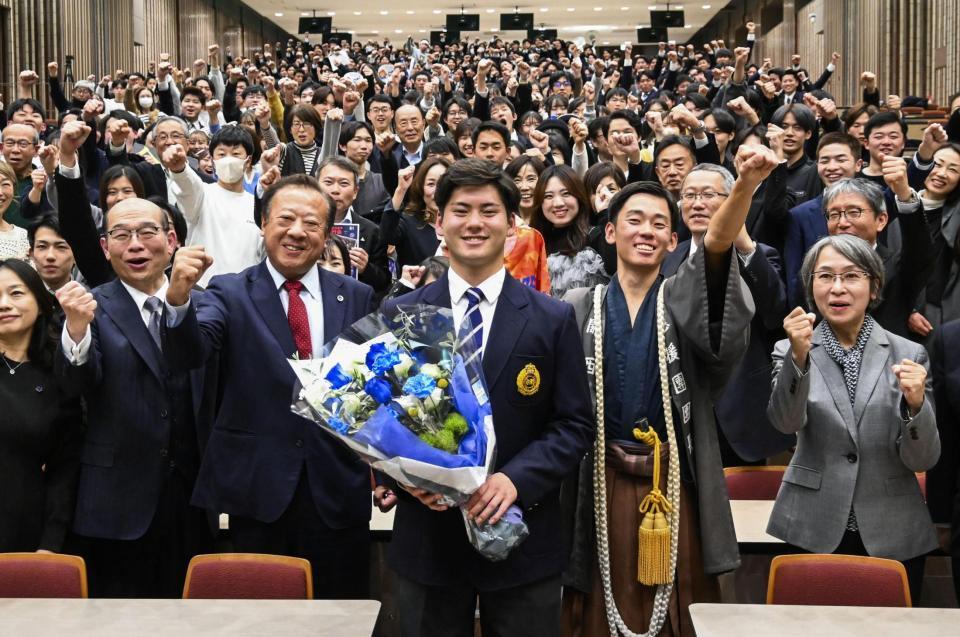 　関大で開かれた壮行会で記念撮影に応じる、ドラフト１位の金丸（中央）