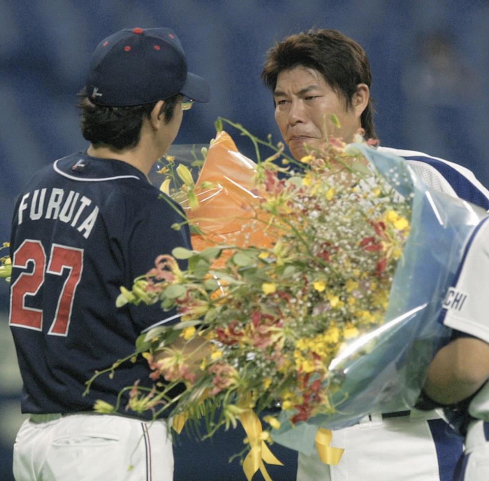 　現役最後の登板を終え、かつてのチームメートのヤクルト・古田（左）から花束を贈られ涙する中日・川崎＝２００４年撮影