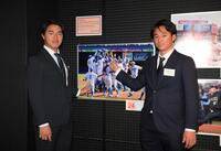 　展示されている全日本大学野球選手権優勝時の写真を指さすロッテ・西川史礁（左）と広島・佐々木泰（撮影・伊藤笙子）