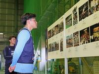 　阪神・淡路大震災のあった１９９５年の記録写真を見入る麦谷（撮影・立川洋一郎）