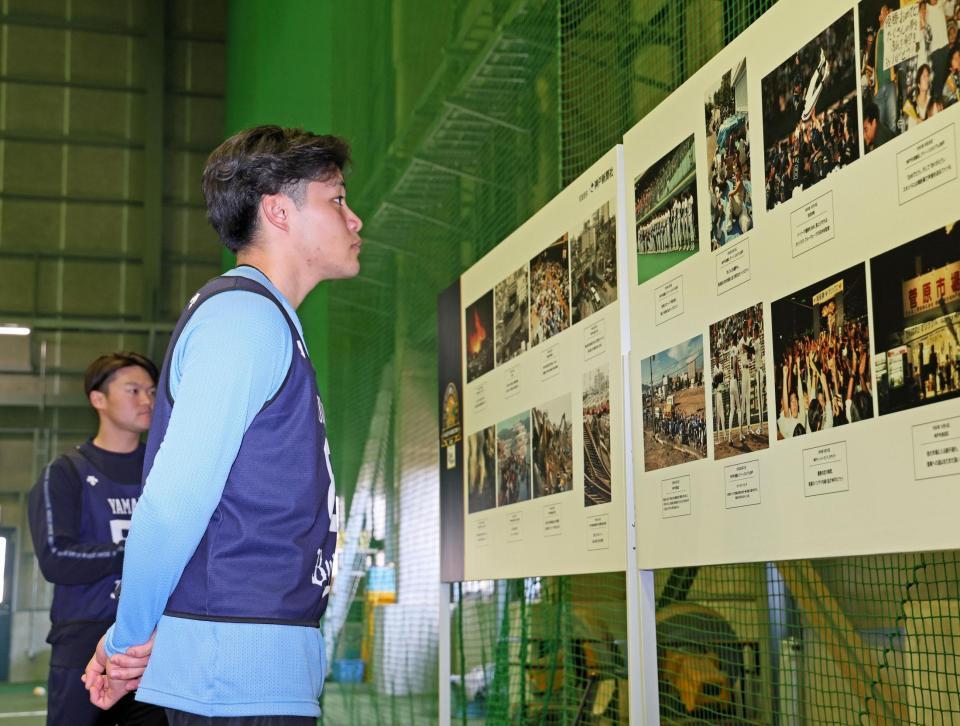 　阪神・淡路大震災のあった１９９５年の記録写真を見入る麦谷（撮影・立川洋一郎）