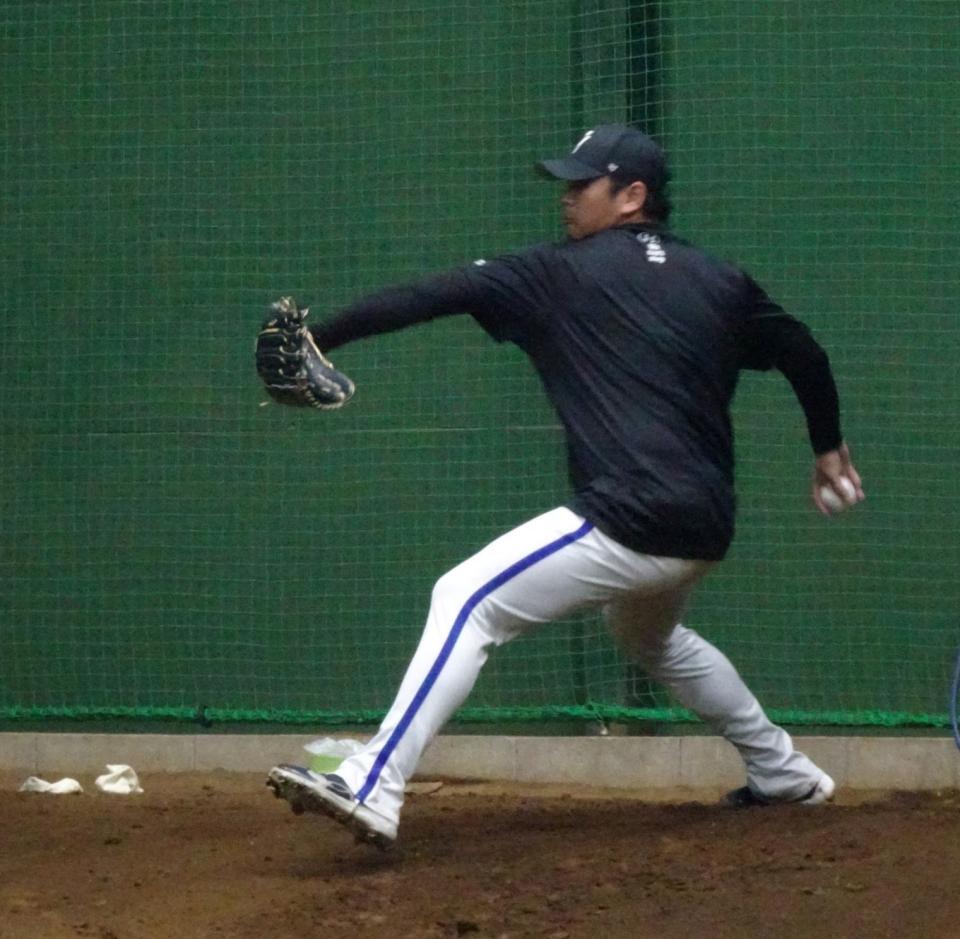　ブルペンで投球練習を行う山崎