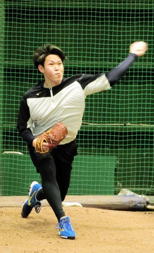 　ブルペンで投球練習をする根本