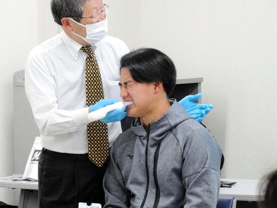　新人選手が口腔健康セミナーを受講、噛む力測定をする西川（右）と東京歯科大学口腔健康科学講座スポーツ歯学研究室の武田友孝教授