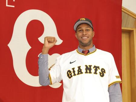 　ユニホームに袖を通し、笑顔でガッツポーズのマルティネス（撮影・西岡正）