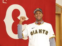 　ユニホームに袖を通し、笑顔でガッツポーズのマルティネス（撮影・西岡正）