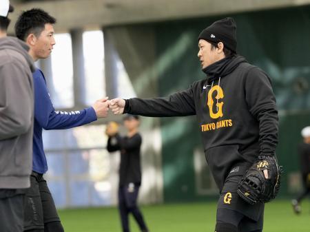 　ブルペンでタッチを交わす巨人の甲斐（右）と戸郷＝宮崎市