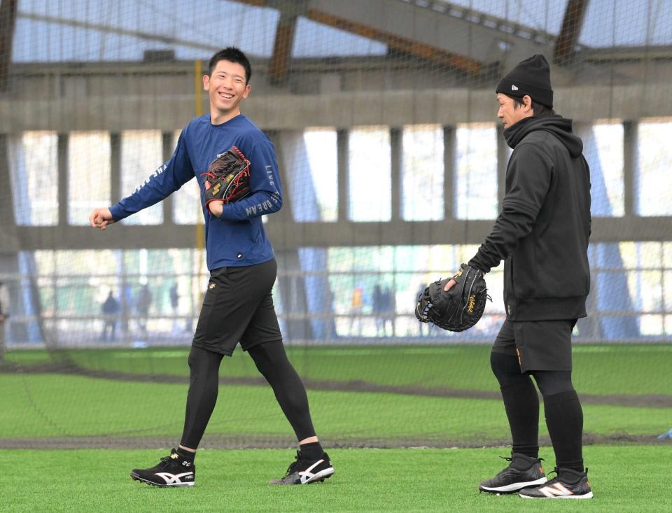 　ブルペンでの投球を終え、相手を務めた甲斐（右）に笑顔を見せる戸郷（撮影・伊藤笙子）