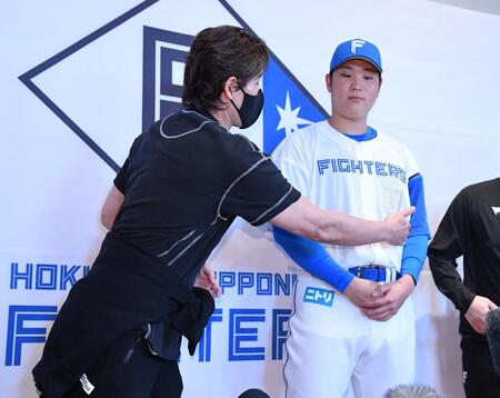 　会見で古林（右）が脇腹を痛めていることを明かす新庄監督（撮影・開出牧）