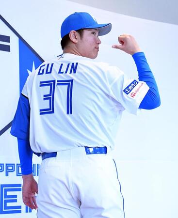 　背番号３７のユニホームに袖を通しポーズを決める古林（撮影・開出牧）