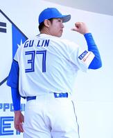 　背番号３７のユニホームに袖を通しポーズを決める古林（撮影・開出牧）