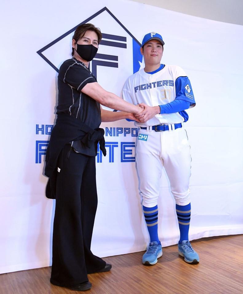 　会見で新庄監督（左）と握手を交わす古林（撮影・開出牧）