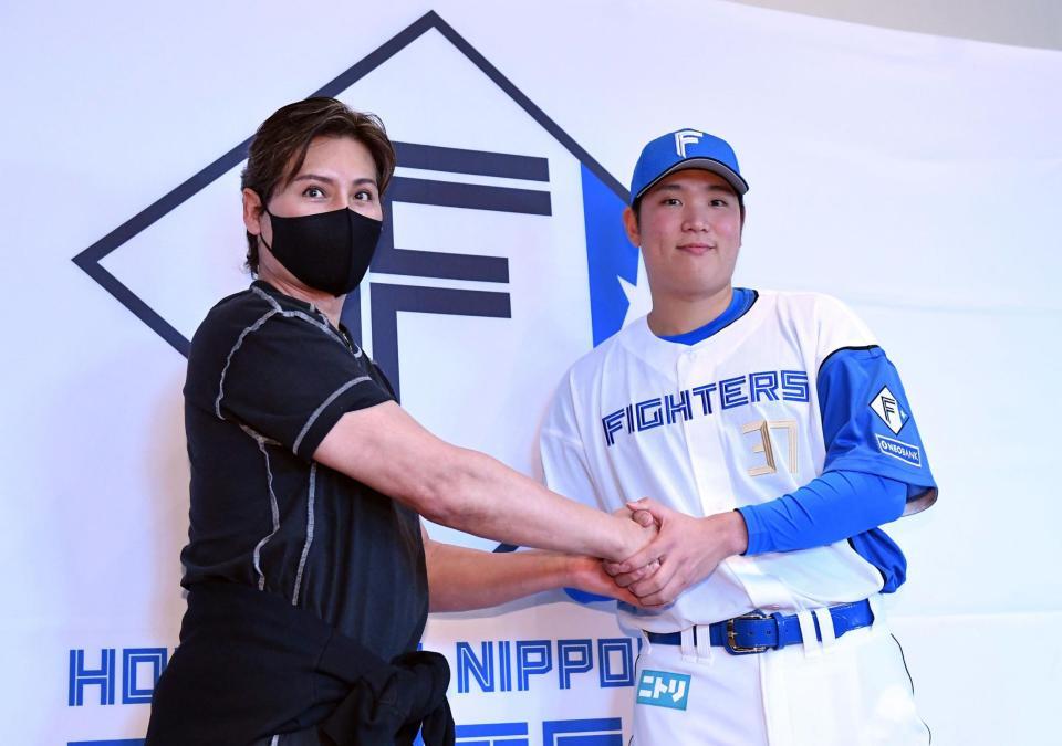 　会見で新庄監督（左）と握手を交わす古林（撮影・開出牧）