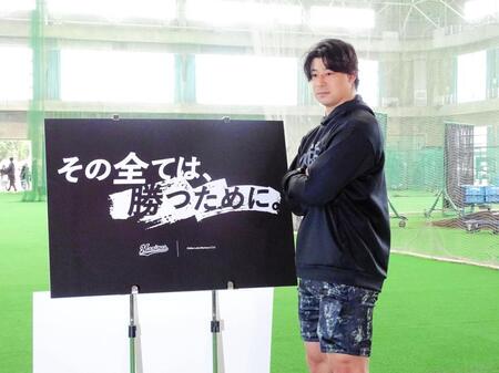 　キャプテンに就任した藤岡はスローガンの前でポーズ