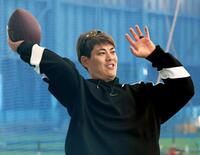 　アメフトのボールでウオーミングアップをする九里（撮影・立川洋一郎）