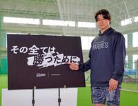 　今季のスローガンが書かれたボードを指さす藤岡