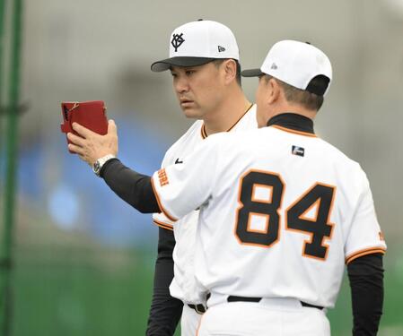 　久保コーチ（手前）が撮影した投球映像を確認する田中将（撮影・伊藤笙子）