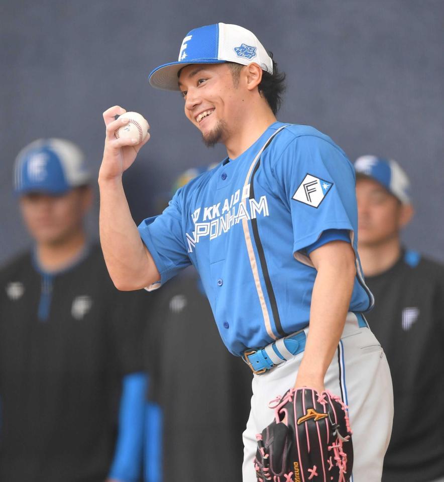 　ブルペンで「キックチェンジ」の握りを見せ、不敵な笑みを浮かべる伊藤（撮影・開出牧）