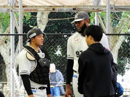 　ブルペンでの投球を終えたゲレーロ（中）は捕手を務めた佐藤と話し合う