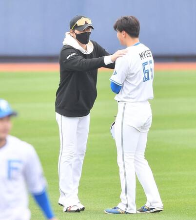 　１軍キャンプ参加の明瀬（右）の肩に手を置き激励する新庄監督（撮影・開出牧）