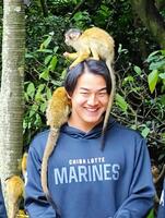 　新人選手がキャンプ休日に「やいま村」を訪問。リスザルに頭に乗られて笑顔の西川