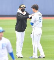 　１軍キャンプ参加の明瀬（右）の肩に手を置き激励する新庄監督（撮影・開出牧）
